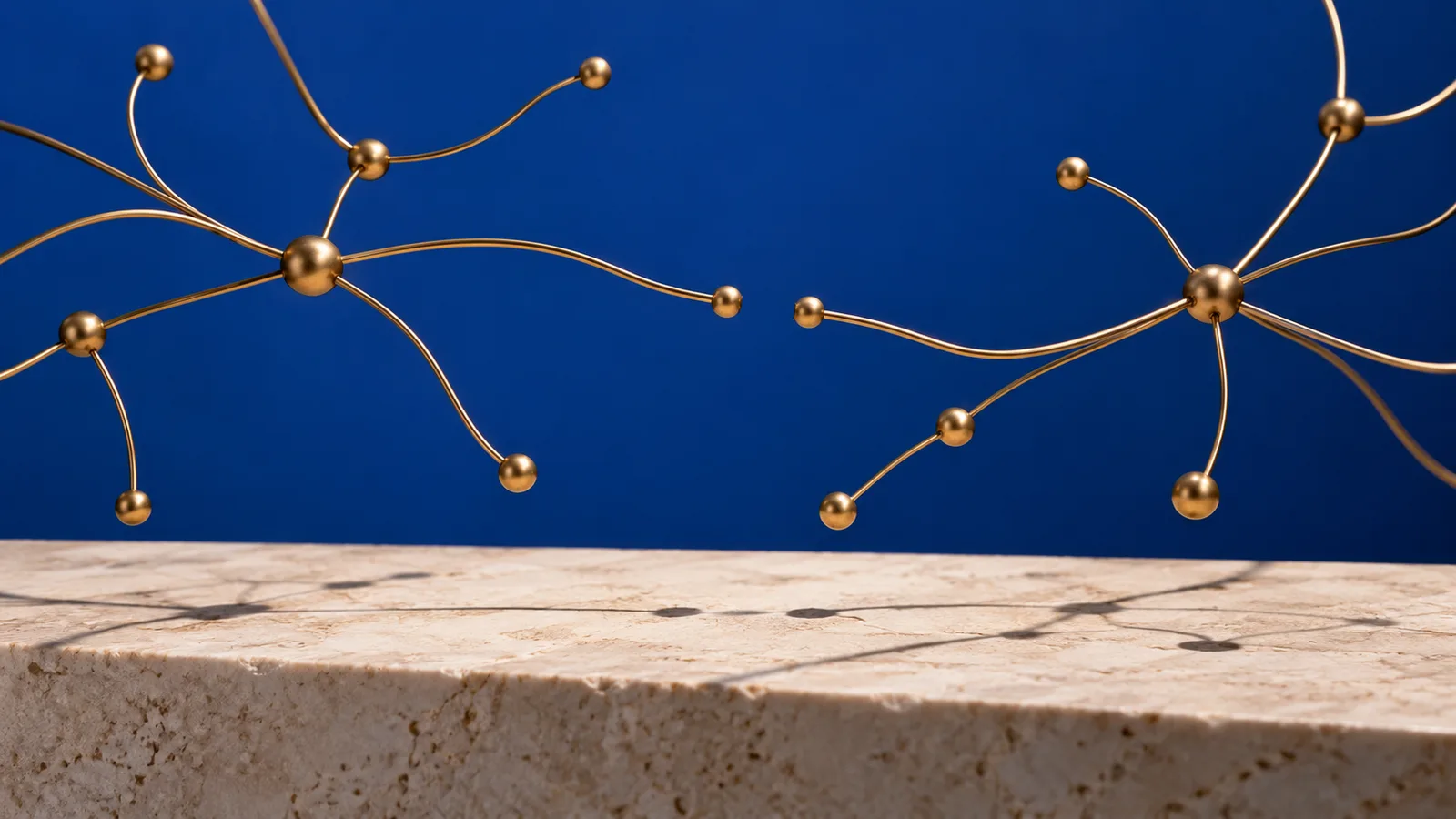 Branching brass-wire network with a small gap against a cobalt background