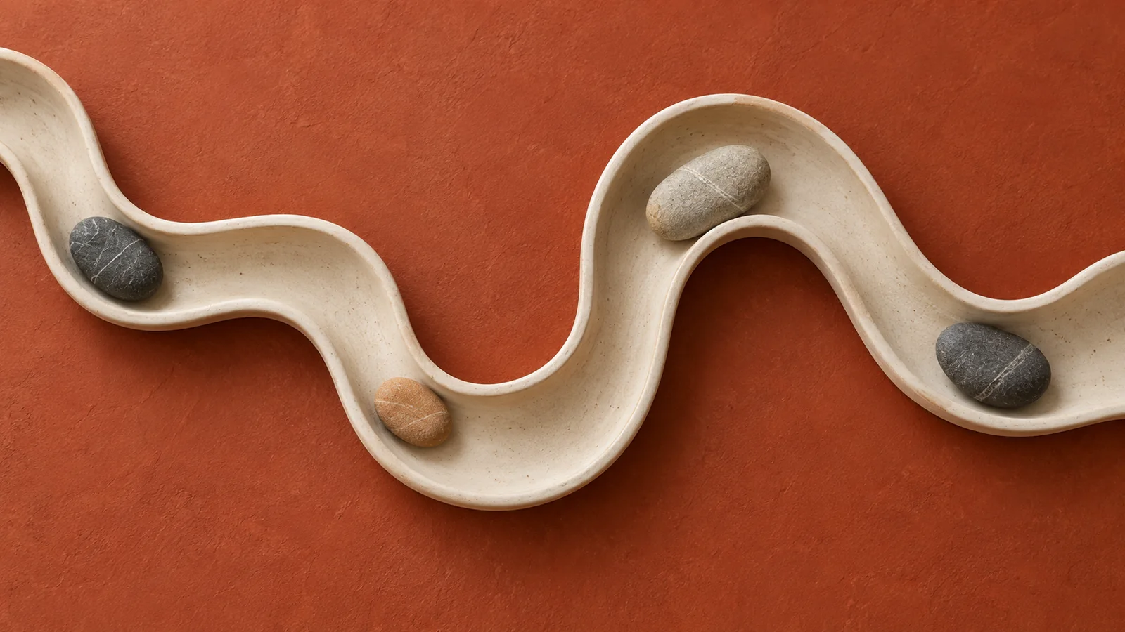 A winding cream ceramic channel with river stones